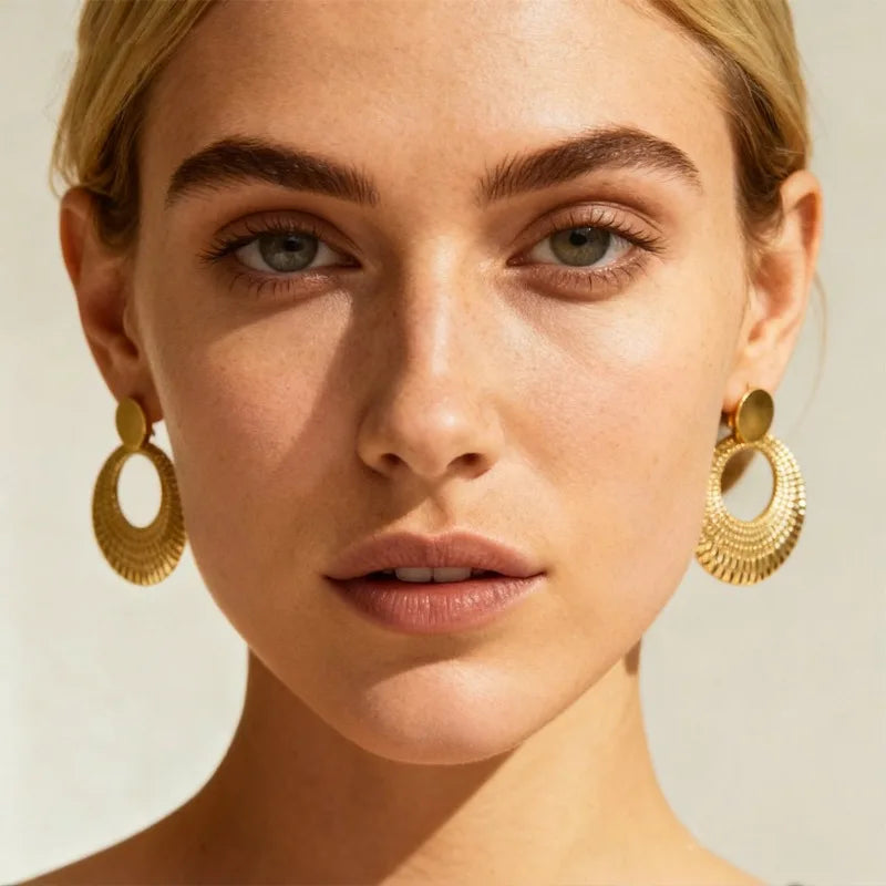 Mujer con pendientes de aro dorados